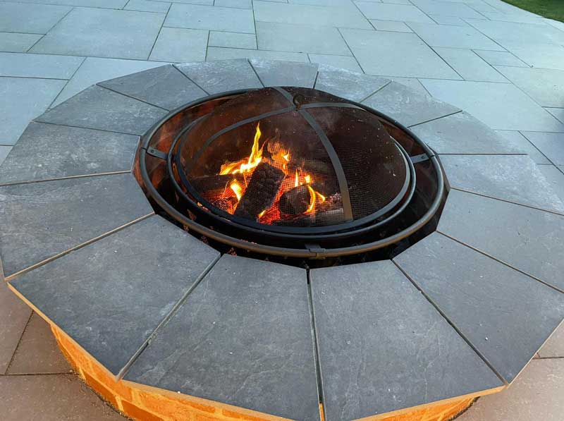 built in raised fire pit with natural stone copings