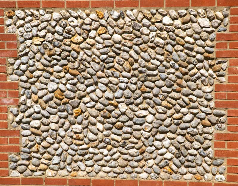 A section of flintwork walling framed by red brick