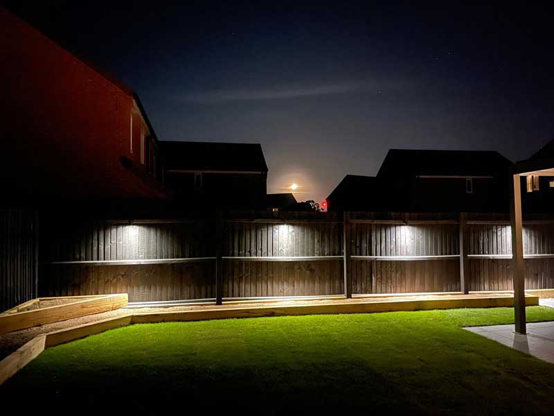 downlighters transform a plain garden fence into something quite lovely