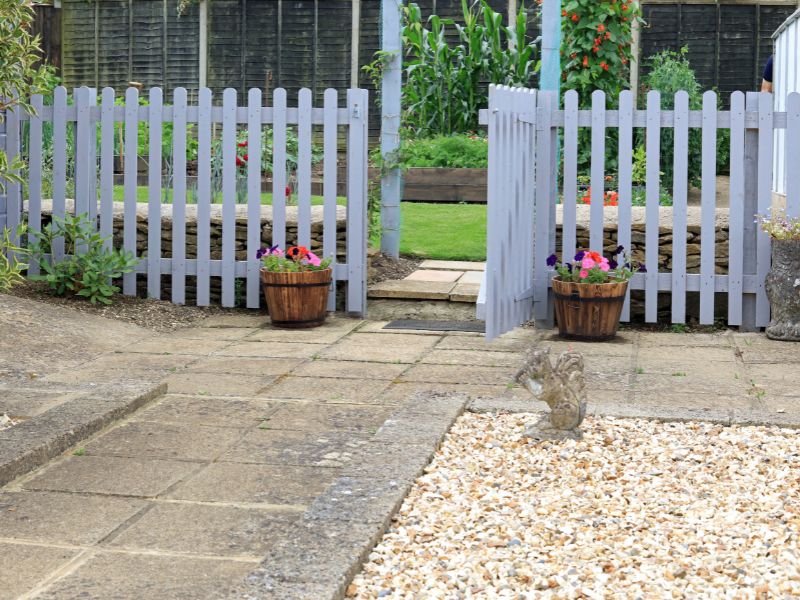 grey painted picket fence used to create zones within a garden.