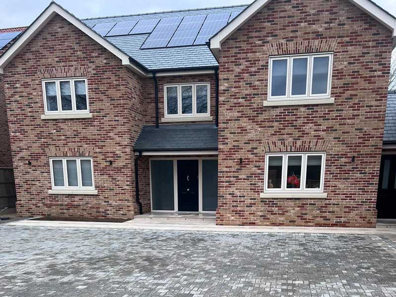 large newbuild property with central front door and solar panels on the roof