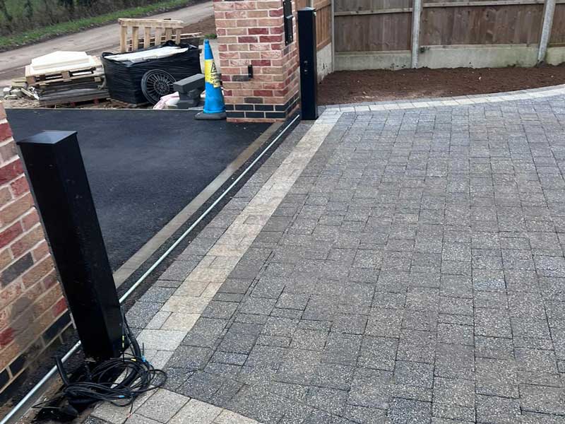 newly landscaped entranceway with tarmac apron and clay paver driveway